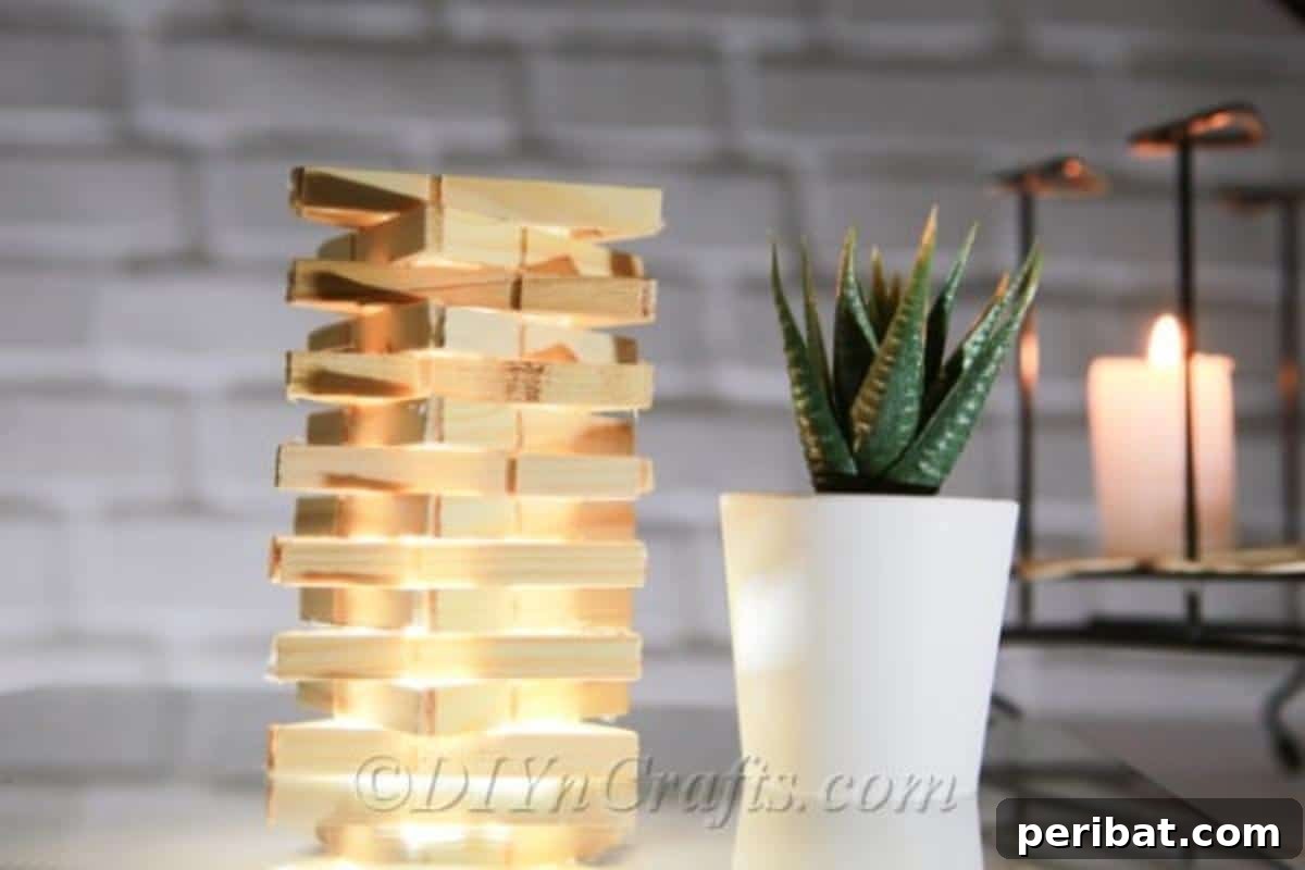 Transform Clothespins into a Stylish Lamp 6 Clothespin lamp displayed next to a small potted plant, enhancing a natural aesthetic.