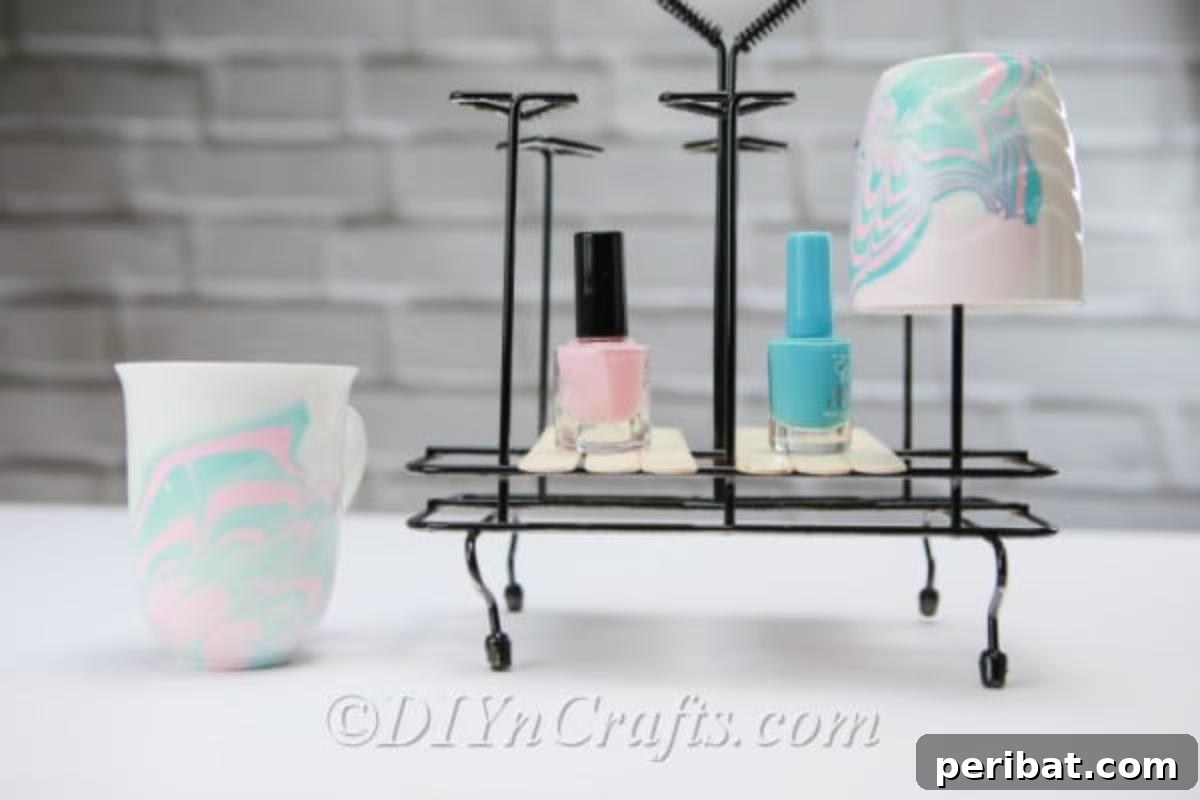 Nail Polish Marble Cup Magic 3 Collection of colorful nail polishes laid out beside two exquisitely marbled coffee cups hanging on a rack.