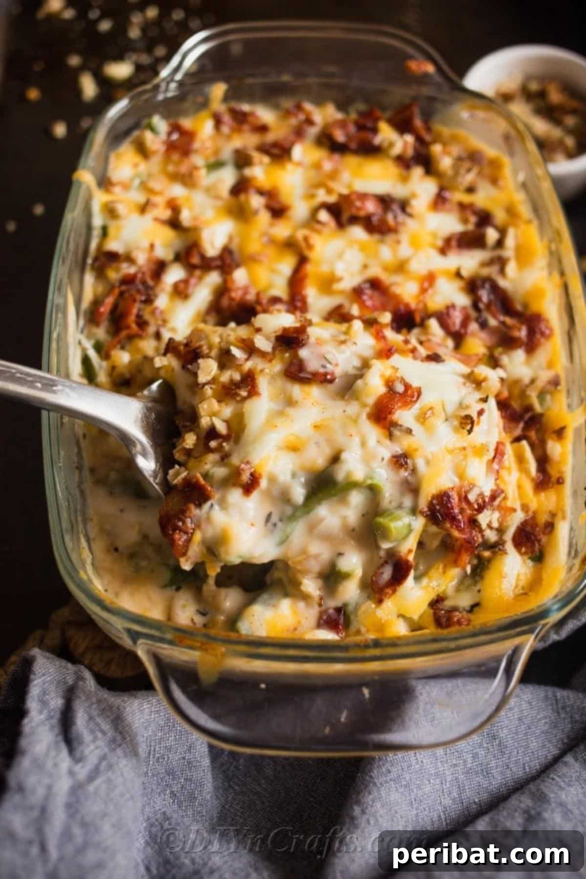 Irresistible Green Bean Casserole 2 A serving of homemade green bean casserole with a spoon, showing its creamy texture and golden-brown topping
