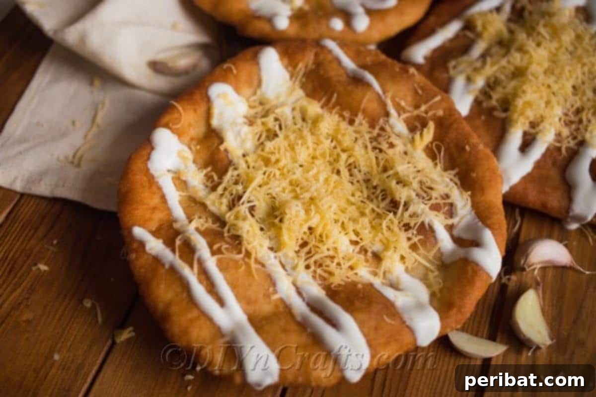 Langos with a small corner piece broken off, showing the airy interior