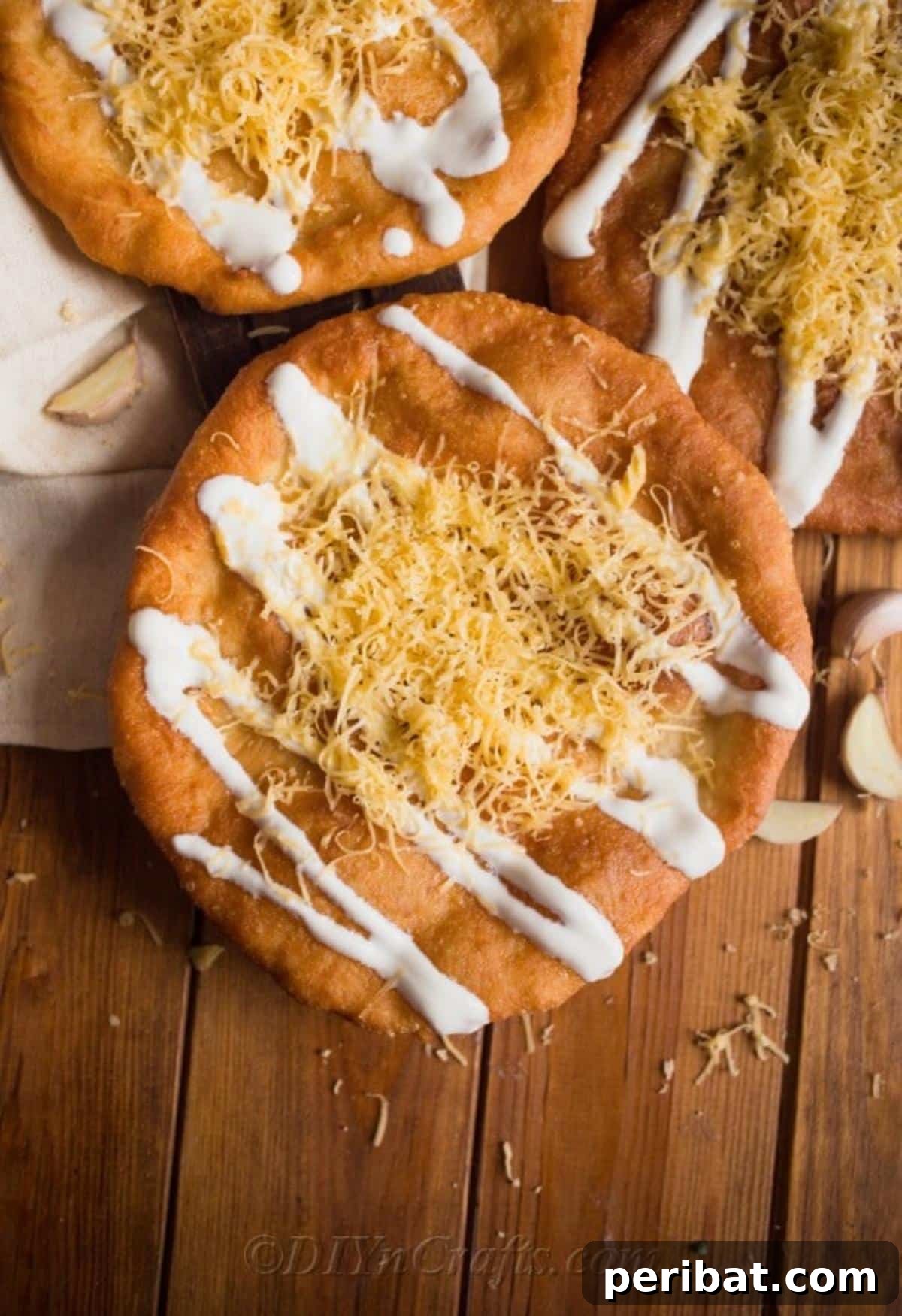 Langos with cheese and sour cream on top, ready to be served