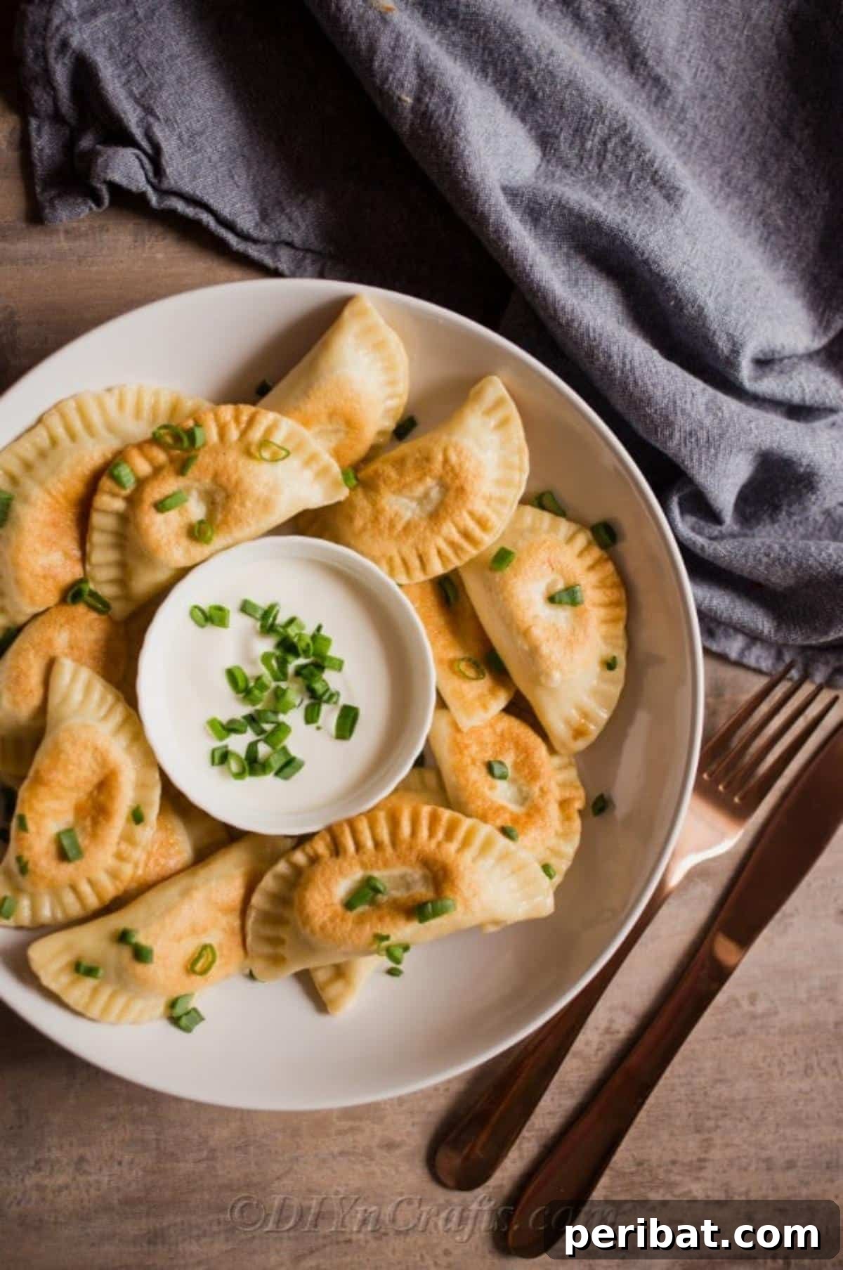 Effortless Potato Pierogi Delight 2 Classic Potato Pierogies served with a dollop of fresh sour cream, garnished lightly.