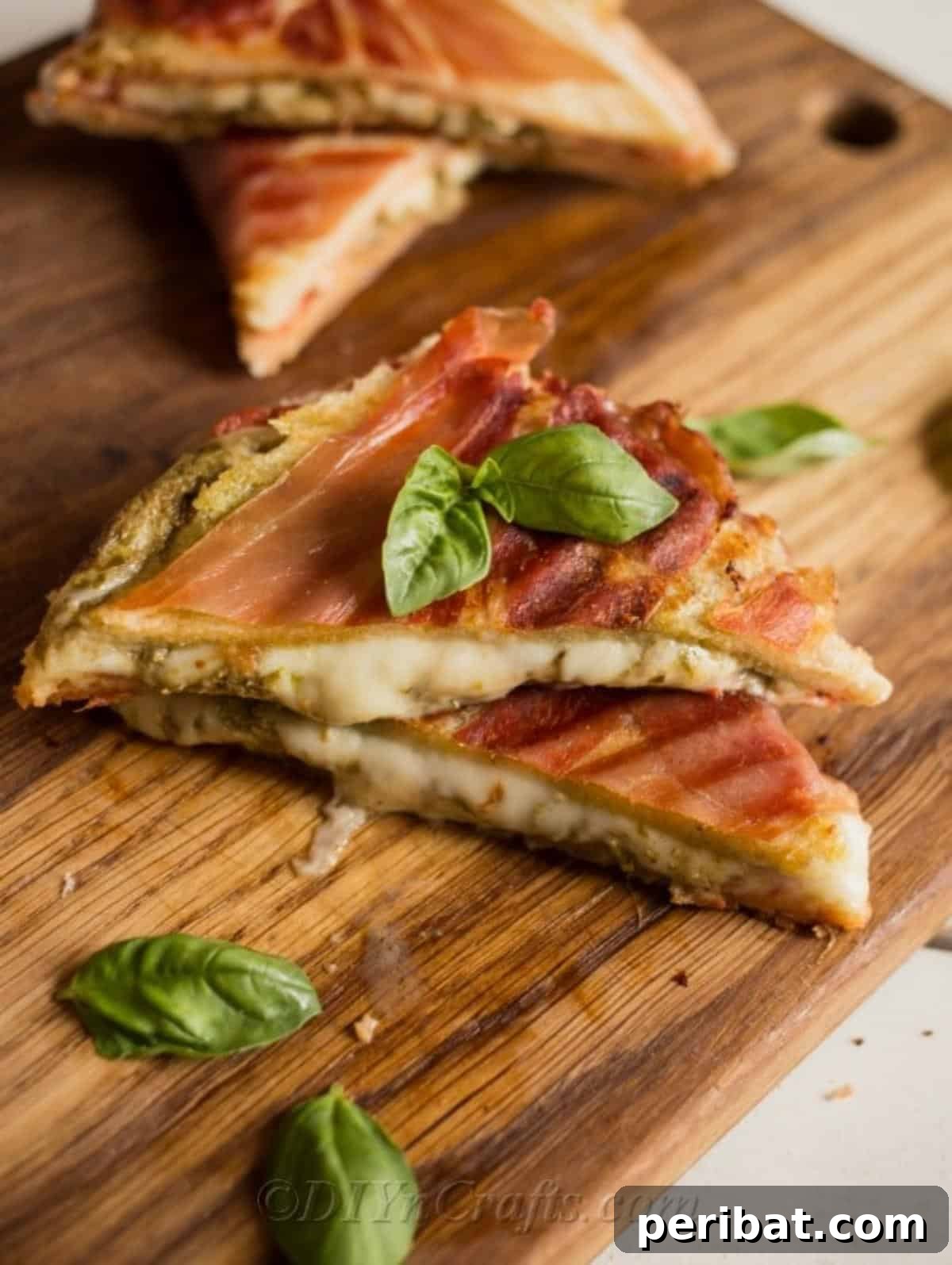 Pesto Perfection Grilled Cheese 4 Pesto grilled cheese sandwich sliced into neat triangles, garnished with fresh basil leaves on a white plate