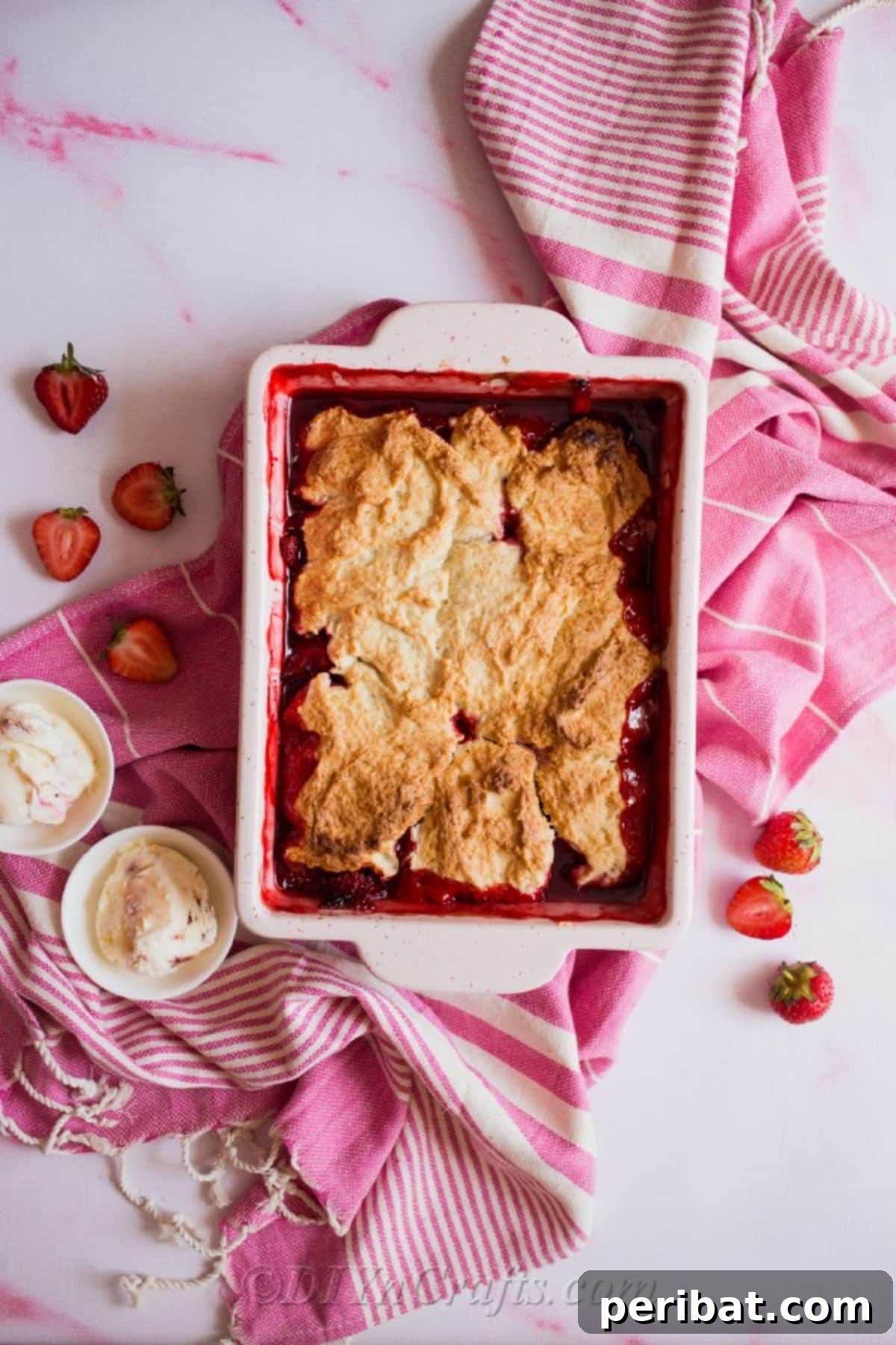 Freshly baked strawberry cobbler in a baking dish, perfect for summer gatherings.