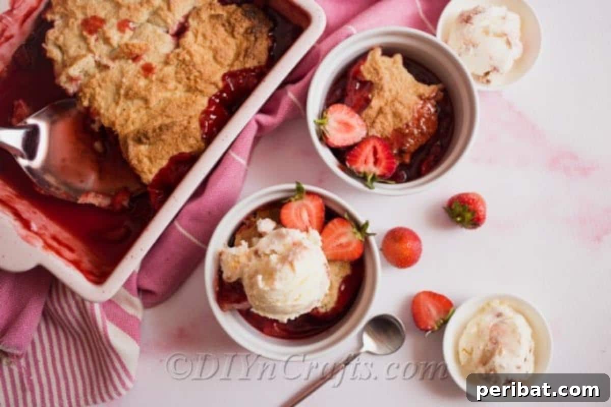 Strawberry cobbler served with ice cream on top in a white bowl, ready to be enjoyed.