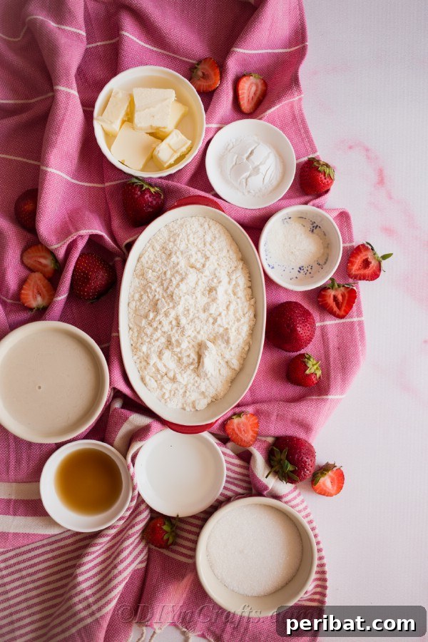 Fresh strawberries and ingredients for cobbler filling laid out.
