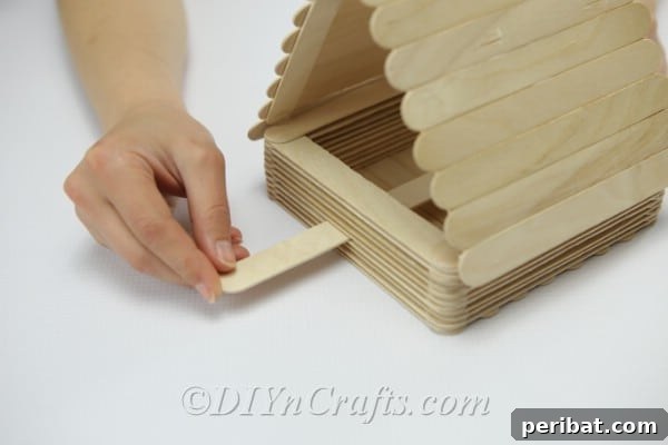 Slide the joined craft sticks through the feeder walls to create a bird perch.