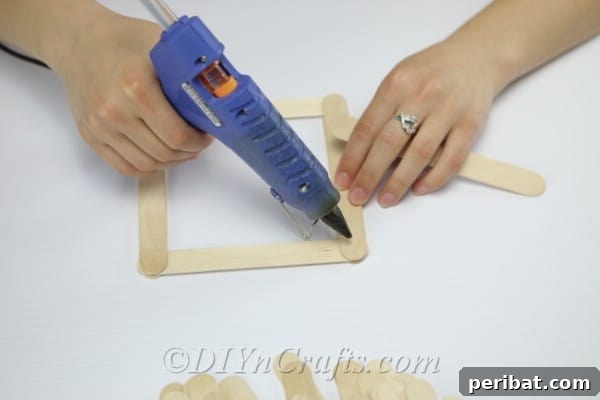 Apply hot glue to all four corners of the craft stick base.