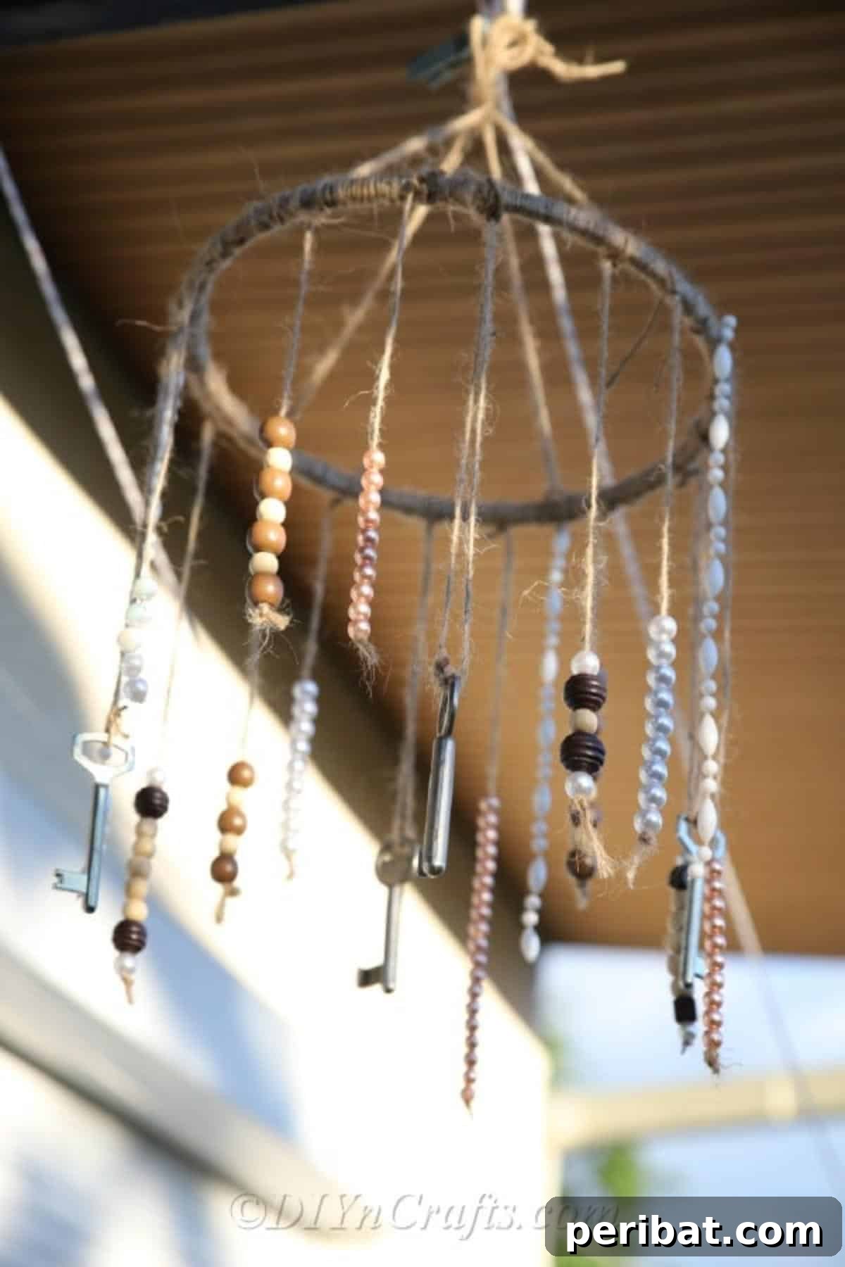 Crafting Your Own Rustic Wind Chime 2 Let’s make our own rustic wind chimes. A finished rustic wind chime with keys and beads hanging from a twine-wrapped wooden hoop.