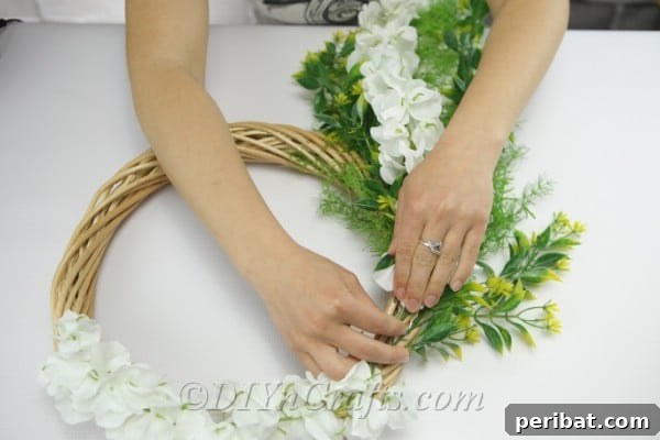 Keep arranging and attaching the flowers to the wreath.