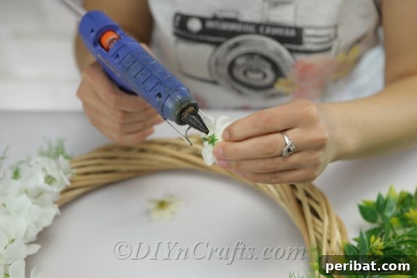 Glue some additional flowers onto the greenery.