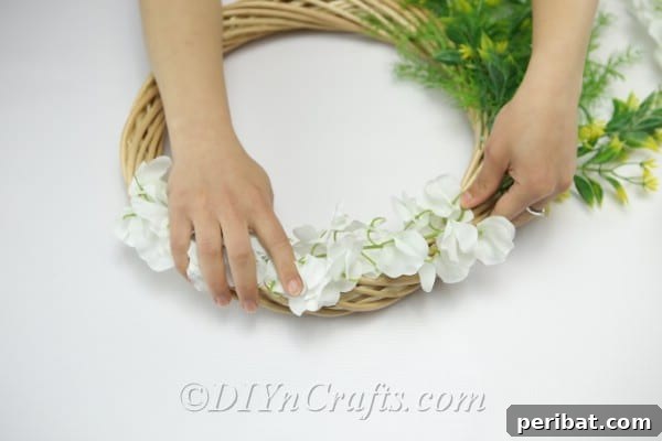 Arrange the flowers on the top part of the wreath.