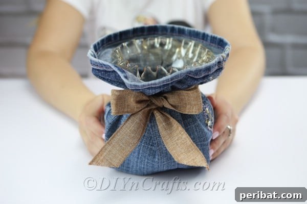 The finished vase with its denim cover and decorative ribbon bow.