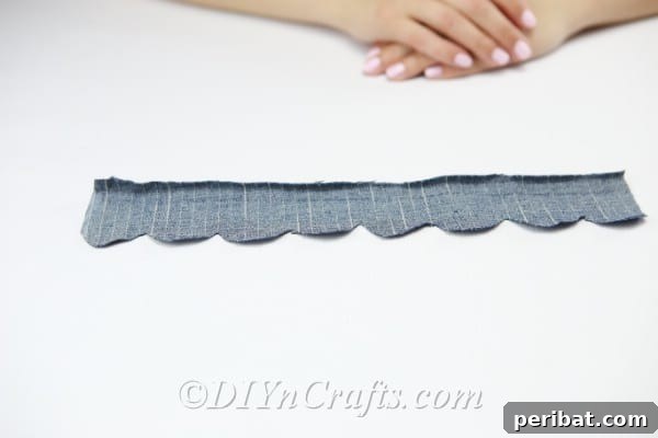 Unfold the denim strip to reveal the continuous scalloped edge for the flower petals.
