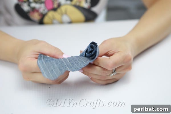 Blooming Denim Art 18 Begin tightly rolling the denim strip, securing with glue, to form the flower.