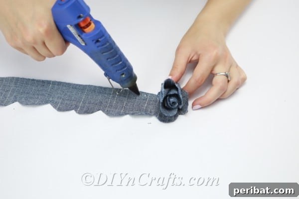 Continue rolling and gluing the denim strip, watching the flower take shape.
