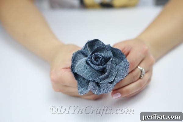 Fan out the scalloped edges of the rolled denim to form a realistic rose.