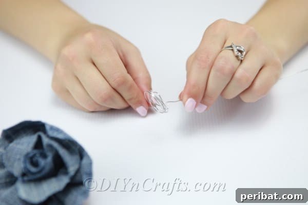 Blooming Denim Art 21 Attach gardening wire securely around the base of the denim rose to create a stem.