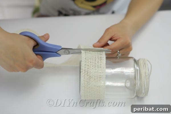 Trim excess ribbon for a clean finish after wrapping the jar.