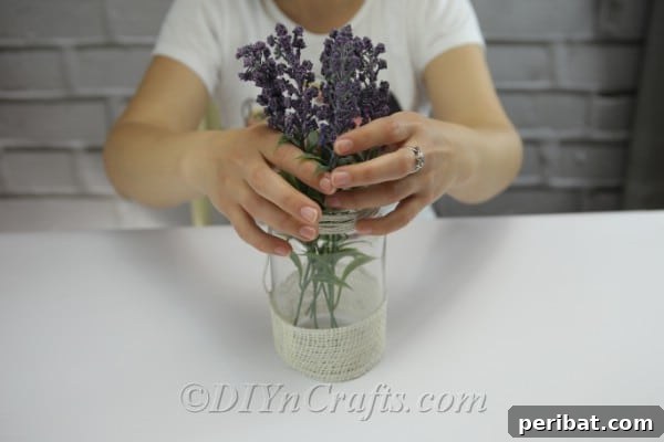 Carefully arrange artificial or fresh flowers inside the jar.
