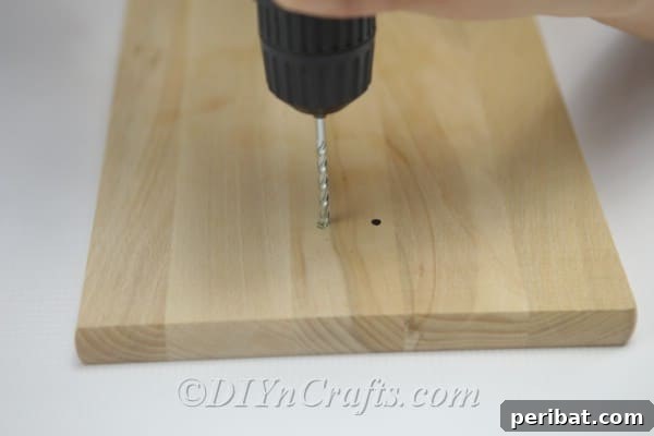 Drill pilot holes into the wood for secure hook attachment.