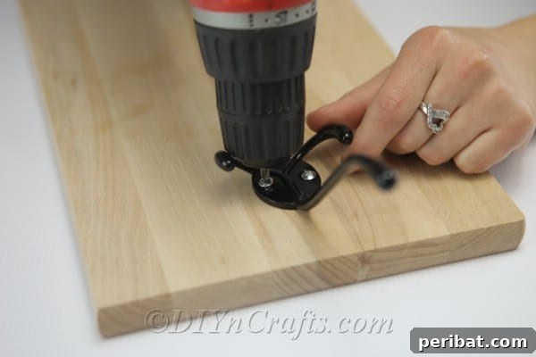 Attach the hook securely to the wooden board using screws.