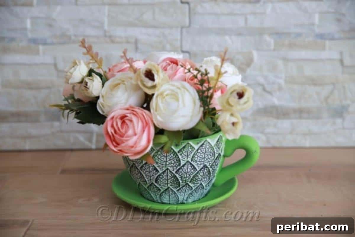 Floral Magic in a Teacup 5 A beautifully arranged teacup floral decor piece positioned on a wooden desk, enhancing an indoor space.