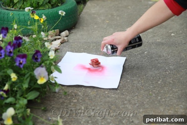 Spray paint your rose any color you like, applying even coats for a professional finish.