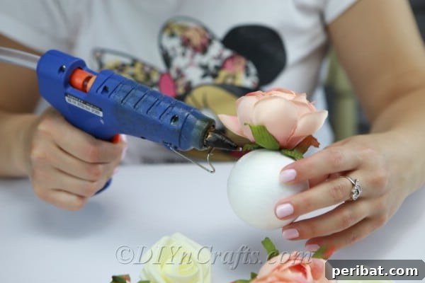 Glue the flowers onto the Styrofoam ball, ensuring full coverage.