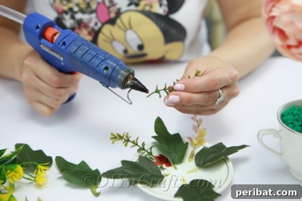 Attach additional leaves and sprigs to the saucer for a cohesive look.