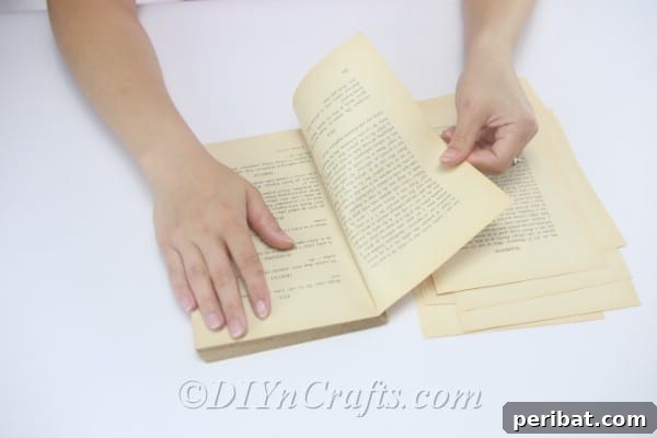 Tear out some old book pages from a vintage book for crafting.