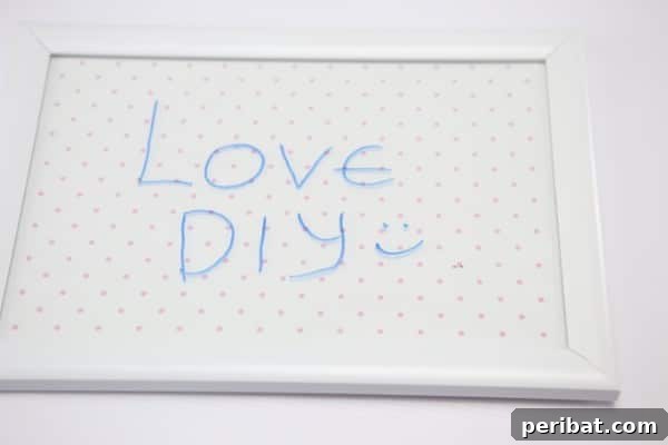 A decorative whiteboard on a desk reads, “Love DIY :)” in colorful dry-erase marker.