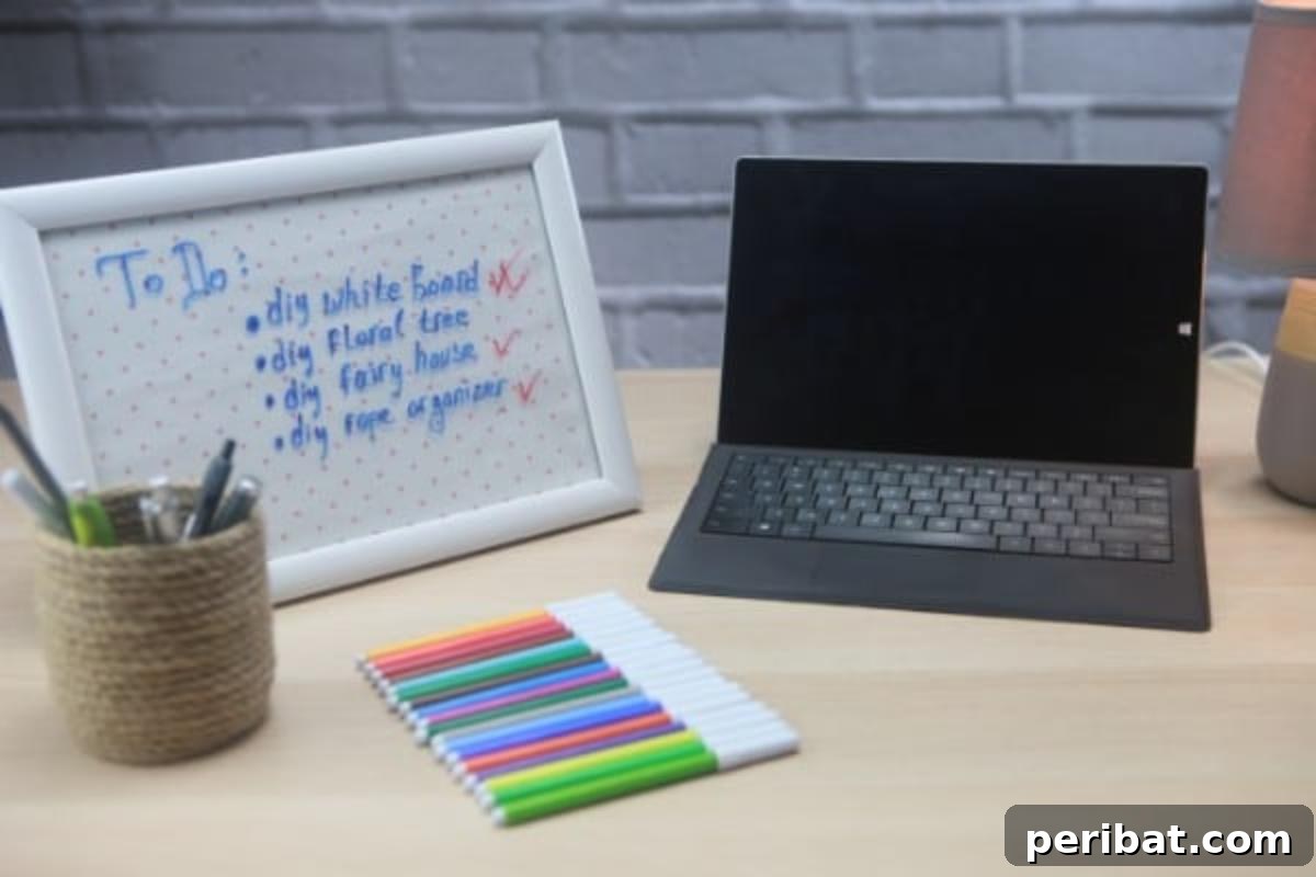Build a Custom Whiteboard for Your Office 3 A handcrafted whiteboard sits elegantly next to a computer and colorful markers, perfectly blending with a cozy home office setup.