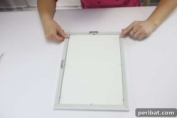 Open the back of the picture frame and remove any existing contents.