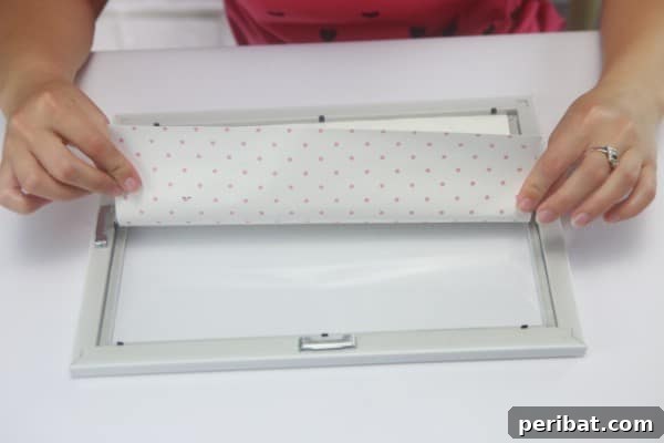 Carefully place the decorative paper face down against the glass inside the frame.
