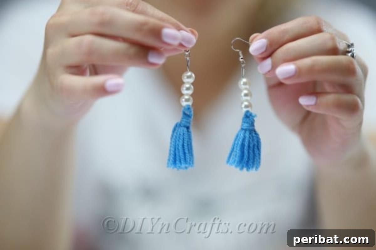 Create Your Own Trendy Yarn Tassel Earrings 2 Finished yarn tassel earrings, colorful and vibrant, held gently in hands, ready to be worn.