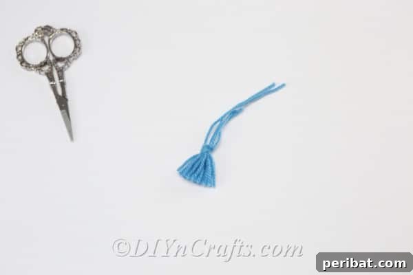 Create Your Own Trendy Yarn Tassel Earrings 9 The tassel begins to take shape with its individual strands hanging neatly after trimming.
