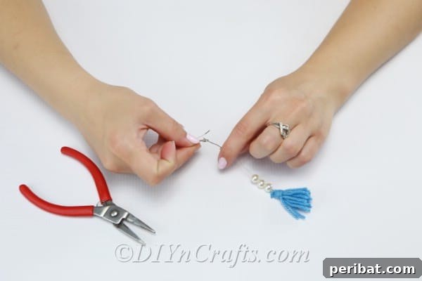Create Your Own Trendy Yarn Tassel Earrings 13 Thread the wire through the bail of the earring hook, connecting it to the beaded tassel.