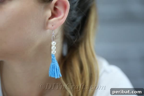 Create Your Own Trendy Yarn Tassel Earrings 16 A woman proudly wears a beautifully crafted yarn tassel earring, highlighting its stylish appeal.