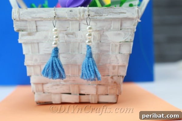 Create Your Own Trendy Yarn Tassel Earrings 18 Handmade yarn tassel earrings artfully arranged on a woven basket, suggesting a bohemian and crafted aesthetic.