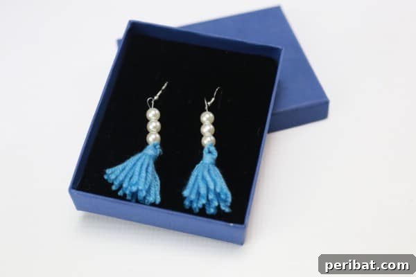 A beautifully crafted pair of yarn tassel earrings with beaded accents, ready for wear or gifting.