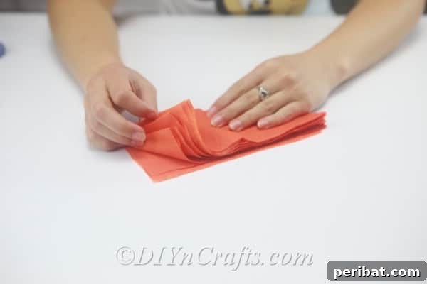 A neat stack of numerous small, identically cut tissue paper strips, ready for the next step.