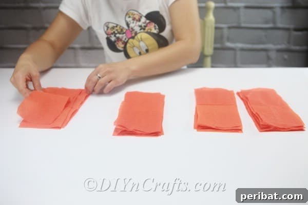Organizing and splitting the prepared tissue paper strips into four equal piles for individual flower components.