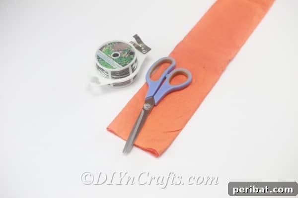 A collection of essential supplies laid out for crafting tissue paper flowers, including folded and cut tissue paper, scissors, and wire.
