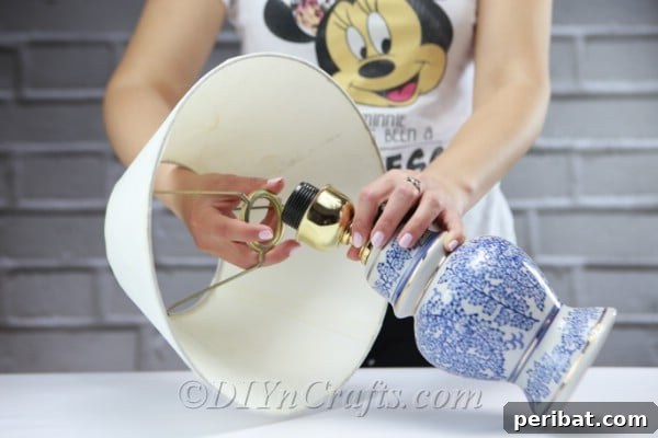 Carefully remove the lampshade from its base and detach any existing light bulb from the socket.
