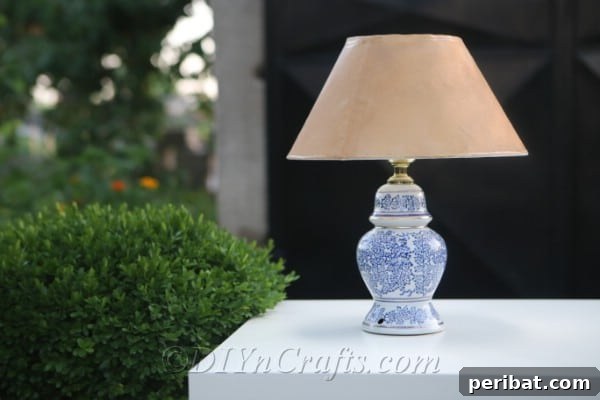 A solar garden lamp sits gracefully on an outdoor table, surrounded by lush greenery, enhancing the garden's ambiance.