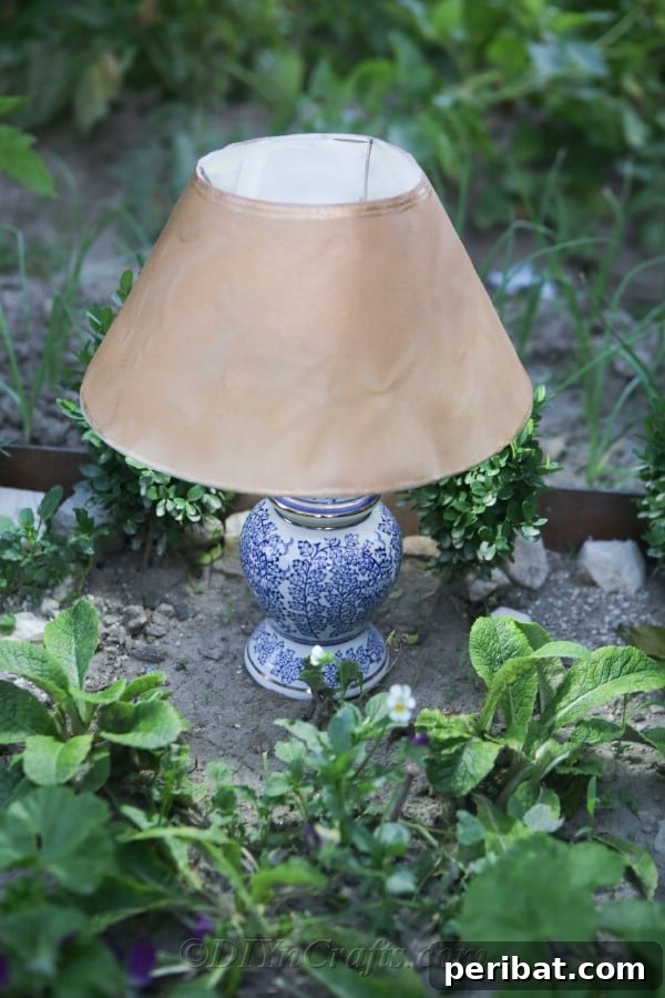 The solar garden lamp's soft light beautifully complements the plants in a garden, creating a serene and inviting atmosphere.