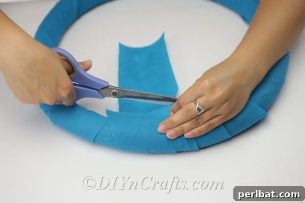 Coastal Elegance: Craft Your Perfect Summer Wreath 12 Trim any excess fabric or paper and secure the ends neatly with hot glue to complete the wrapping.