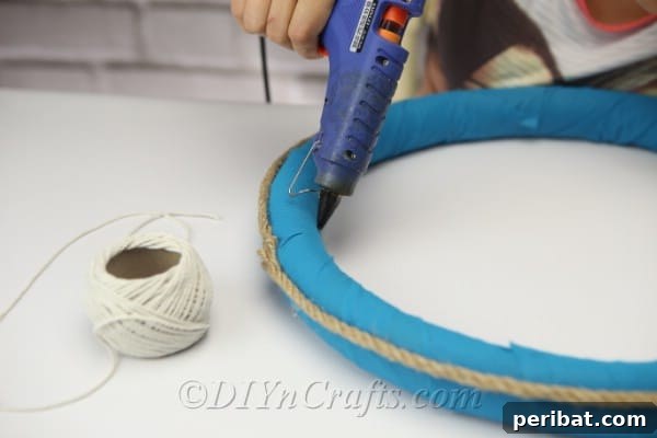 Coastal Elegance: Craft Your Perfect Summer Wreath 15 Use hot glue to secure the white string to the wreath at one of the rope seam points.