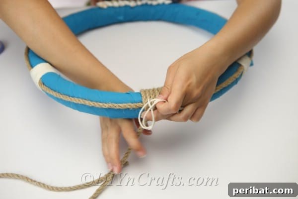 Coastal Elegance: Craft Your Perfect Summer Wreath 22 Continue wrapping the rope tightly around the top section of the wreath.